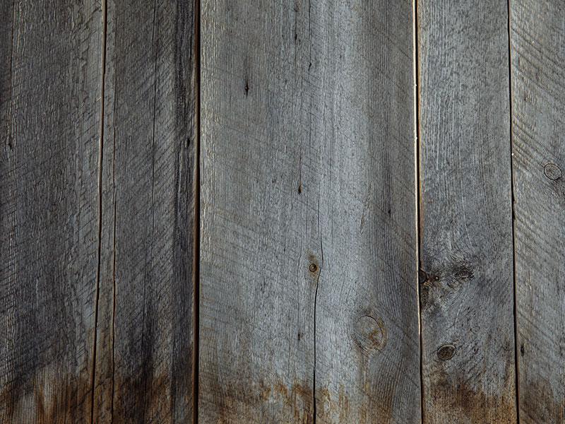 A water-damaged wood panel needs repair.